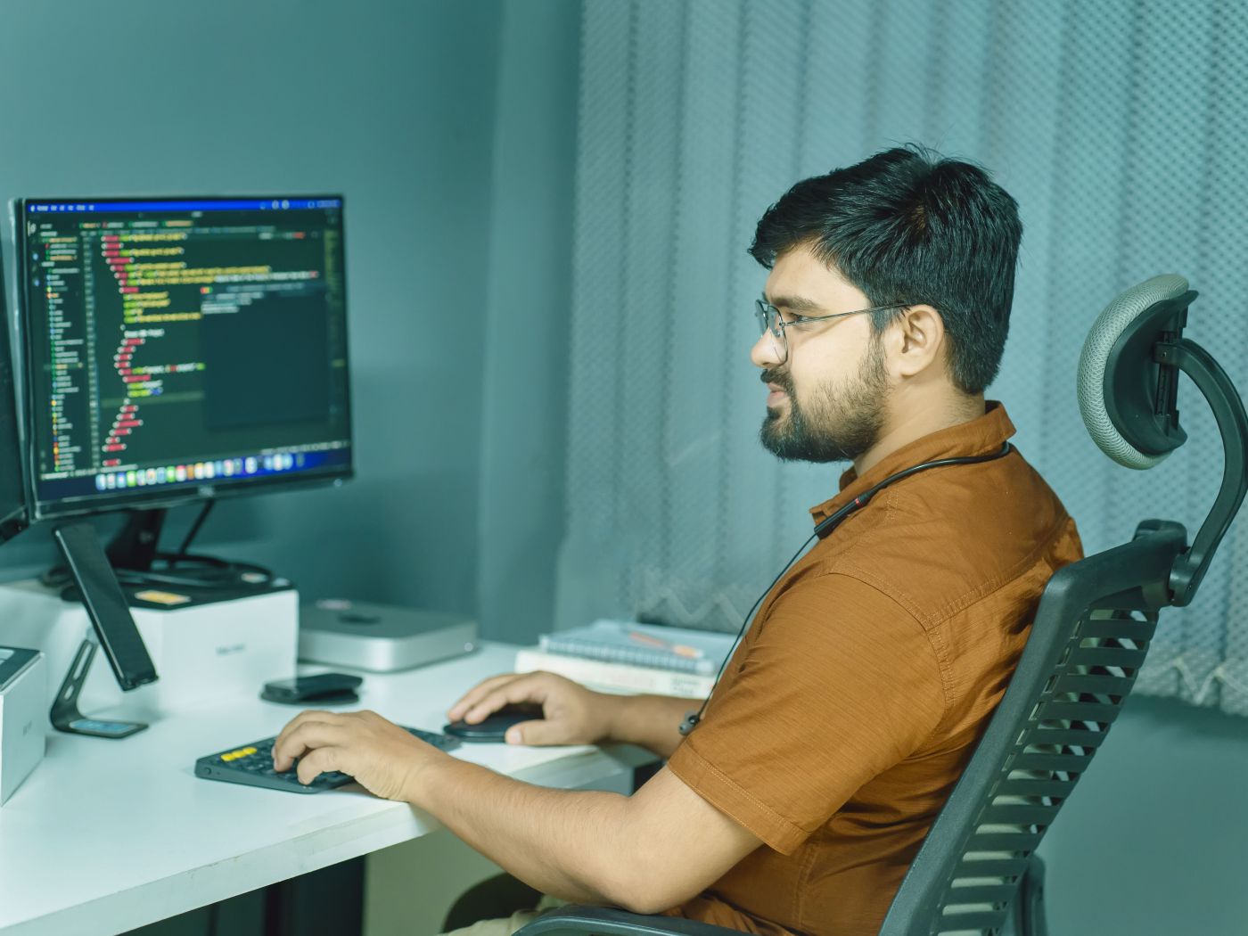 Developer reviewing website code across two monitors